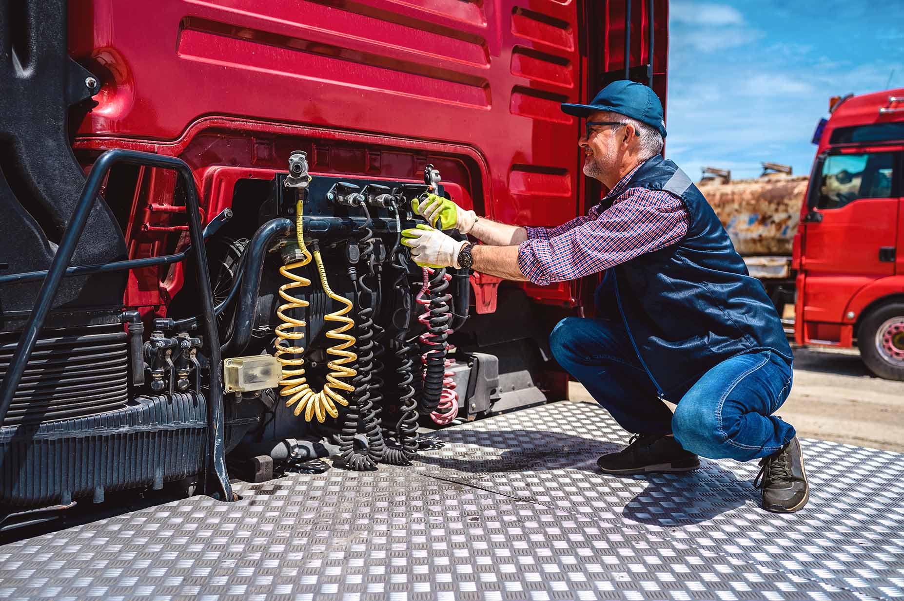 A man checking a truck’s tire pressure.